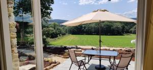 a table and chairs with an umbrella on a patio at Galician Rural Accommodation - La Casita in Lugo