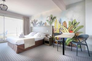 a hotel room with a bed and a table and chairs at Hôtel La Petite Sirène Quiberon in Quiberon