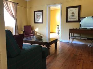 a living room with a couch and a table and a tv at Comfrey Cottage in Lady Grey