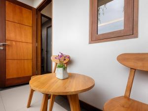 a vase of flowers sitting on a table next to two stools at Kubu Belona Canggu in Canggu +9 photos