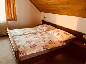 ein Bett mit zwei Kissen darauf in einem Schlafzimmer in der Unterkunft Appartements D'Angelo in Bodensdorf