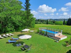 um grande quintal com piscina, cadeiras e guarda-sóis em Liberty Villa with private garden and pool by VacaVilla em Turignano