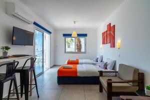 Sala de estar con cama y mesa en Tangerine Studio with Pool in Ayia Napa en Ayia Napa