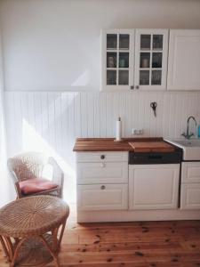 a kitchen with a counter and a chair and a sink at Urlaub auf einem alten Resthof am Meer in Gelting