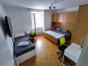 a small room with two beds and a desk and a table at Silvo Apartments in Koper