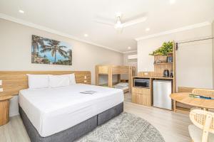 a bedroom with a bed and a kitchen with a table at Seagulls in Townsville