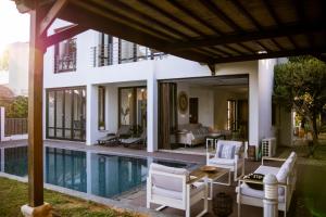 a villa with a swimming pool and white furniture at Balinese in Ayia Napa