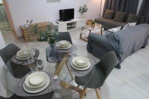 a dining table and chairs in a living room at J & E Málaga Center Apartamentos in Málaga