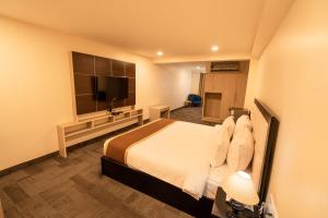 a hotel room with a bed and a flat screen tv at ROYALE LALAWI HOTEL in Āīzawl