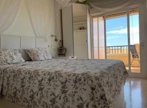 een slaapkamer met een bed en uitzicht op een balkon bij Penthouse Isla de Altea in Altea
