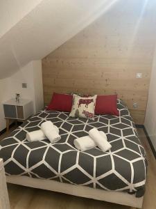 Muhlbach-sur-MunsterにあるAu p’tit nid douillet de Léaのベッドルーム1室(大型ベッド1台、赤と白の枕付)