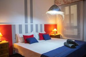 una camera da letto con un grande letto con cuscini rossi e blu di Luxury Singular Apartments a Santiago de Compostela