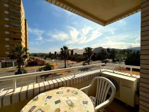 een balkon met een tafel en uitzicht op een straat bij ACV- Marina Trebol III-2ª Linea planta 1 sur-3 habitaciones in Oropesa del Mar