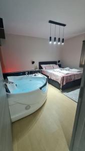 a bathroom with a bath tub and two beds at Mias luxury spa apartment in Rijeka