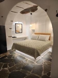 um quarto com uma cama num arco em Sea Melody Tinos em Ayios Sostis