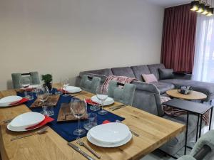 a dining room with a table with plates and wine glasses at Mias luxury apartment in Rijeka