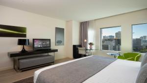 a hotel room with a bed and a flat screen tv at Crowne Plaza Tel Aviv City Center, an IHG Hotel in Tel Aviv