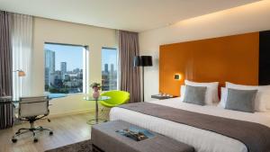 a hotel room with a bed and a desk and window at Crowne Plaza Tel Aviv City Center, an IHG Hotel in Tel Aviv