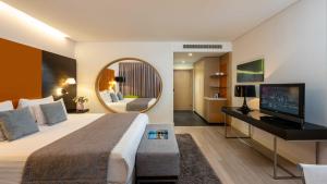 a hotel room with a large bed and a mirror at Crowne Plaza Tel Aviv City Center, an IHG Hotel in Tel Aviv