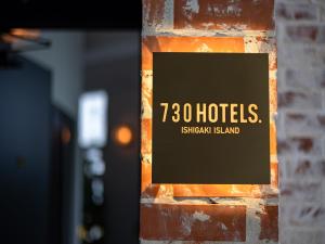 石垣岛730HOTELS.的砖墙边的标志