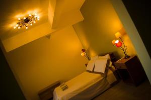 Kleines Zimmer mit einem Bett und einer Lampe in der Unterkunft Room in Villa - Comfortable and welcoming Suite with terrace overlooking the lake in Antananarivo