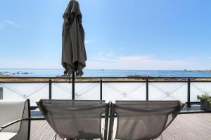 an umbrella sitting on top of a balcony with the ocean at Hôtel La Petite Sirène Quiberon in Quiberon