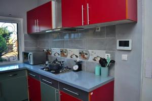 a kitchen with red cabinets and a counter top at Room in Villa - Comfortable and welcoming Suite with terrace overlooking the lake in Antananarivo