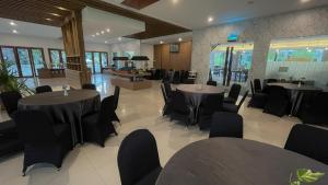 uma sala de jantar com mesas e cadeiras num edifício em LPP Garden Hotel em Yogyakarta