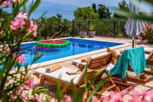 una piscina con 2 sillas de césped y una piscina en Island Getaway - Heritage House with heated pool, en Mirce