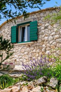 a stone building with a window with green shutters at Island Getaway - Heritage House with heated pool in Mirce