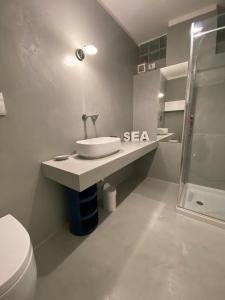 een witte badkamer met een wastafel en een toilet bij Residence Luna in Lignano Sabbiadoro
