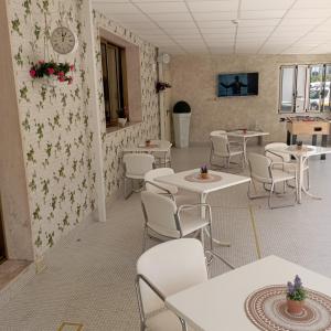 uma sala de jantar com mesas e cadeiras e um relógio na parede em Hotel Raul em Riccione