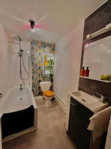 uma casa de banho com uma banheira, um WC e um lavatório. em Charmant studio à deux pas de la cathédrale em Chartres