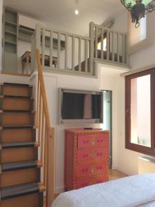 ein Schlafzimmer mit einer Treppe, einem TV und einem Bett in der Unterkunft Farmaki Residence, Plaka in Athen