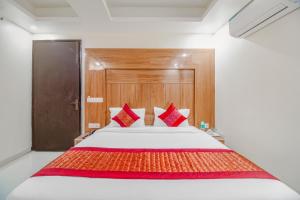 a bedroom with a large bed with red pillows at Hotel Classic Paradise Inn in New Delhi