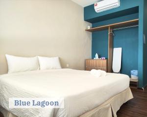 um quarto com uma grande cama branca e um quarto azul em Roxy Sematan Townhouse - Blue Lagoon em Sematan