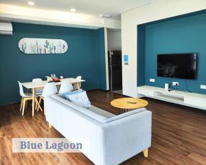 a living room with a white couch and a table at Roxy Sematan Townhouse - Blue Lagoon in Sematan