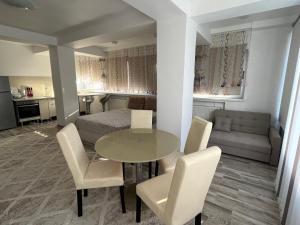 コンスタンツァにあるAri Apartment Bulevardul Mamaiaのテーブル、椅子、ベッドが備わる客室です。