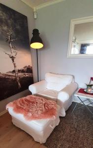 a living room with two white chairs and a table at Stor leilighet nær Bodø sentrum. in Bodø