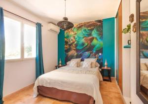 Les Jardins d'Holi proche Uzès في Garrigues-et-Sainte-Eulalie: غرفة نوم مع لوحة طاووس كبيرة على الحائط