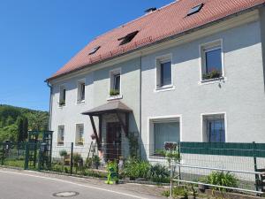 ein großes weißes Haus mit rotem Dach in der Unterkunft Ferienwohnung Simmert in Kurort Gohrisch