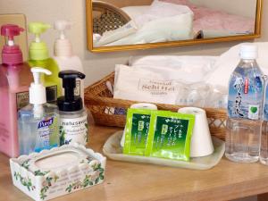 um balcão de casa de banho com uma cesta de sabão e produtos de higiene pessoal em Gasthof Schi Heil em Nozawa Onsen