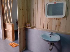a bathroom with a sink and a tv on the wall at Tay Bac Sky Homestay in Sa Pa