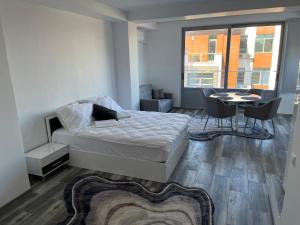 コンスタンツァにあるAri Apartment Bulevardul Mamaiaのベッドルーム1室(ベッド1台、テーブル、椅子付)