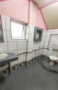 a bathroom with a toilet and a sink at Dongorit Cabin Deluxe Room in Kundasang