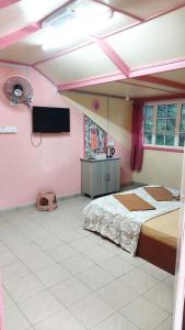 a bedroom with a bed and a flat screen tv at Dongorit Cabin Deluxe Room in Kundasang