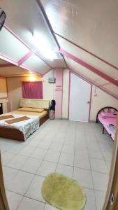 Kampong KundassanにあるDongorit Cabin Deluxe Roomのベッド2台とラグが備わる広い客室です。