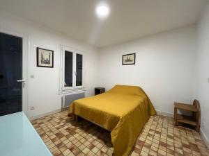 1 dormitorio con 1 cama con manta amarilla en River place, en Villemeux-sur-Eure