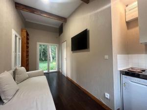 sala de estar con cama blanca y TV en River place, en Villemeux-sur-Eure