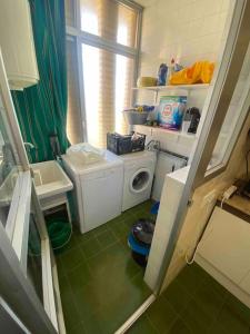 een kleine badkamer met een wasmachine en een wasmachine bij Apartament Near The Beach in San Javier